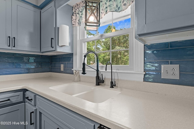 4912 Cypress Shores Dr, New Bern, NC 28562 - kitchen with a sink, gray cabinets, light countertops, decorative backsplash, and plenty of natural light