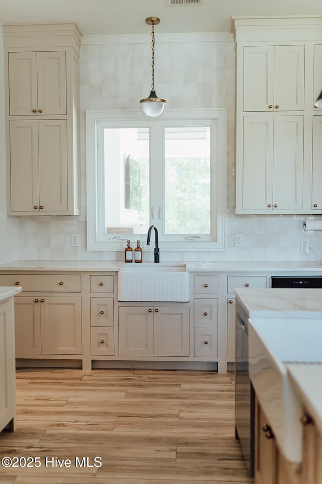 187 Royal Palms Way, Holly Ridge, NC 28445 - kitchen featuring a sink, hanging light fixtures, light countertops, tasteful backsplash, and light wood finished floors