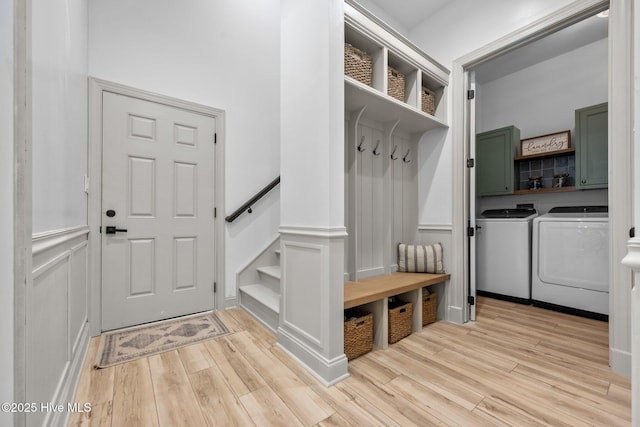 187 Royal Palms Way, Holly Ridge, NC 28445 - mudroom with washing machine and dryer, light wood-style flooring, a wainscoted wall, and a decorative wall