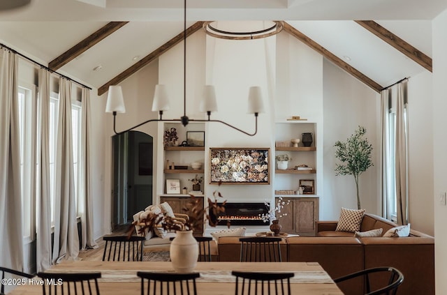 187 Royal Palms Way, Holly Ridge, NC 28445 - dining room featuring high vaulted ceiling, beam ceiling, a glass covered fireplace, built in features, and wood finished floors