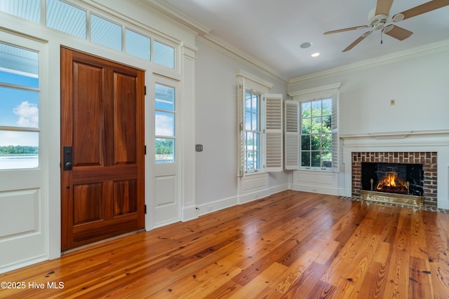 588 E Harborside Rd, Oriental, NC 28571 - entryway featuring wood finished floors, crown molding, a brick fireplace, a ceiling fan, and recessed lighting