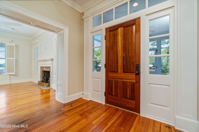 588 E Harborside Rd, Oriental, NC 28571 - entrance foyer with ornamental molding, light wood-type flooring, a fireplace, and baseboards
