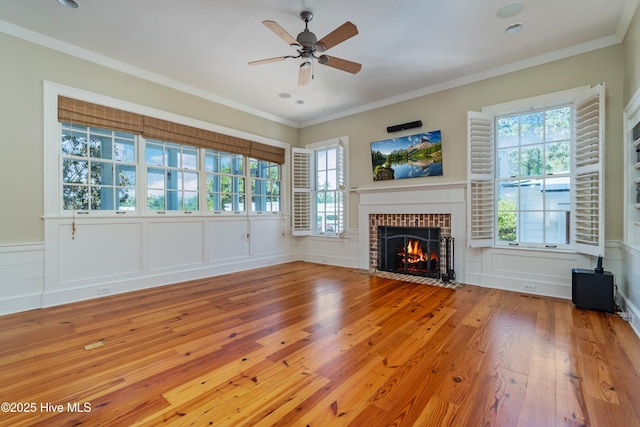 588 E Harborside Rd, Oriental, NC 28571 - unfurnished living room featuring hardwood / wood-style floors, a fireplace, a ceiling fan, a decorative wall, and plenty of natural light