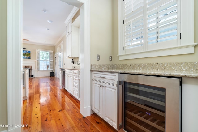 588 E Harborside Rd, Oriental, NC 28571 - bar with beverage cooler, light wood-style floors, a fireplace, ornamental molding, and a sink