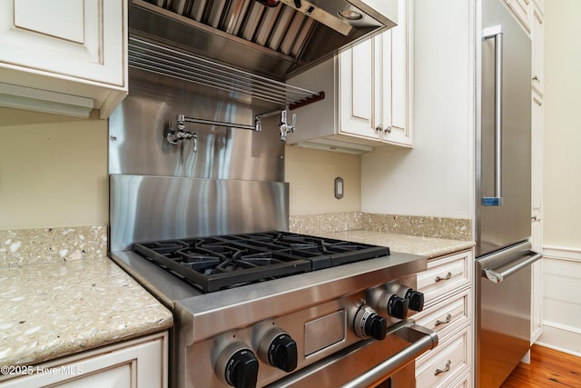588 E Harborside Rd, Oriental, NC 28571 - kitchen with premium appliances, premium range hood, wood finished floors, and light stone counters