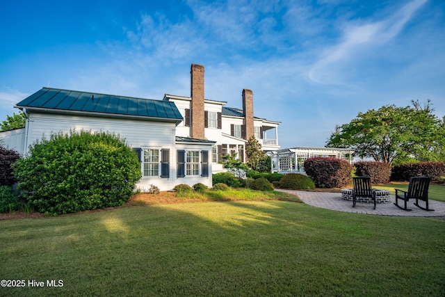 588 E Harborside Rd, Oriental, NC 28571 - back of house featuring a standing seam roof, a chimney, a lawn, a patio, and metal roof