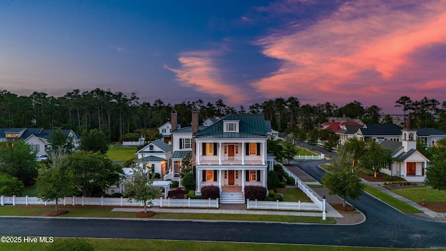 588 E Harborside Rd, Oriental, NC 28571 - greek revival house with a balcony, a porch, a fenced front yard, a standing seam roof, and metal roof