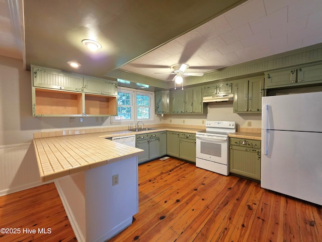 1700 Green Springs Rd, New Bern, NC 28560 - kitchen featuring white appliances, under cabinet range hood, a sink, tile counters, and light wood-style flooring