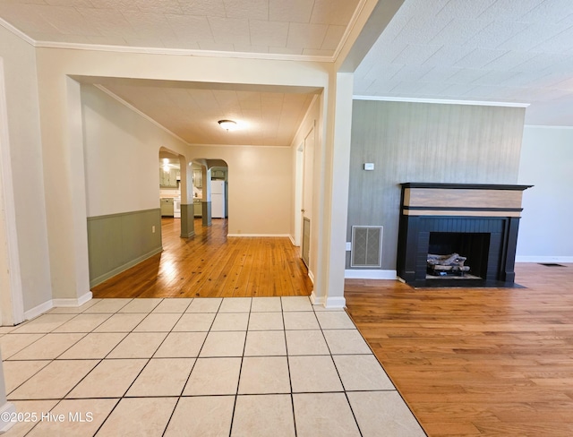 1700 Green Springs Rd, New Bern, NC 28560 - unfurnished living room with crown molding, wood finished floors, arched walkways, a brick fireplace, and baseboards
