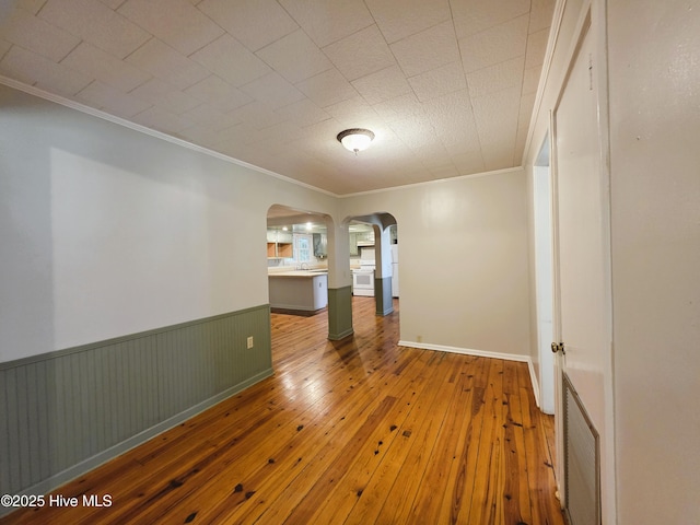 1700 Green Springs Rd, New Bern, NC 28560 - spare room with arched walkways, ornamental molding, wood-type flooring, and wainscoting