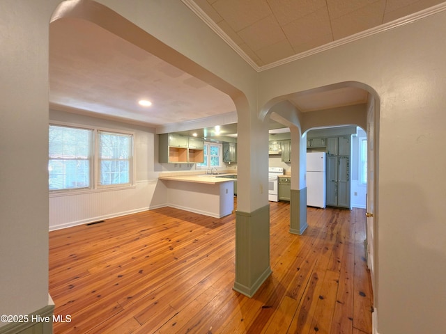 1700 Green Springs Rd, New Bern, NC 28560 - kitchen featuring a peninsula, ornamental molding, white appliances, hardwood / wood-style flooring, and light countertops
