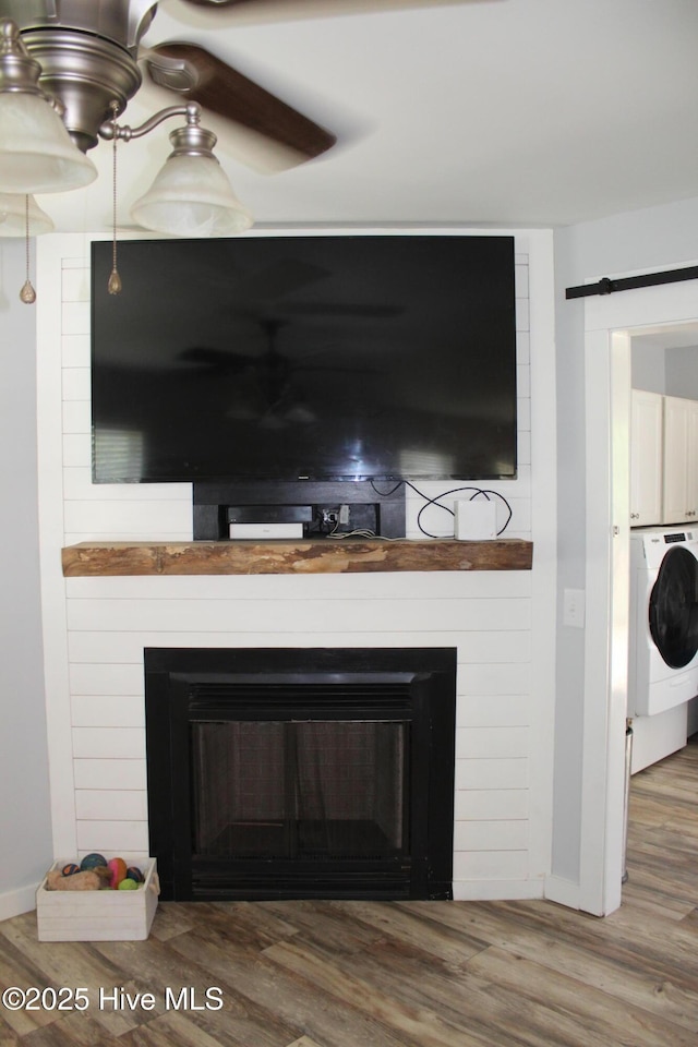 121 Pine Grove Rd, Newport, NC 28570 - detailed view of washer / dryer, a fireplace, baseboards, and wood finished floors