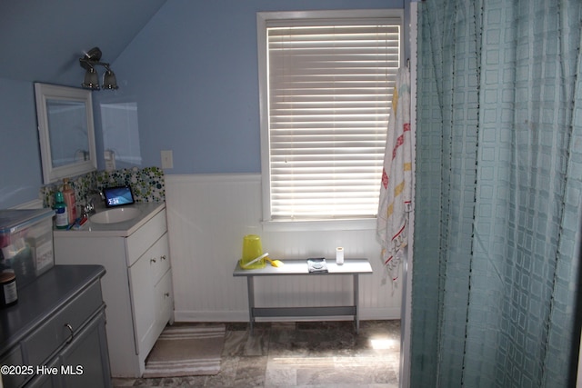 121 Pine Grove Rd, Newport, NC 28570 - full bathroom featuring healthy amount of natural light, vanity, vaulted ceiling, a shower with shower curtain, and a wainscoted wall