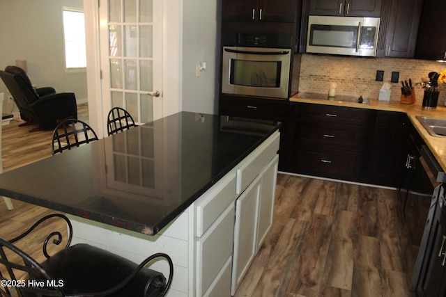 121 Pine Grove Rd, Newport, NC 28570 - kitchen featuring stainless steel appliances, dark wood-type flooring, a kitchen breakfast bar, backsplash, and a center island