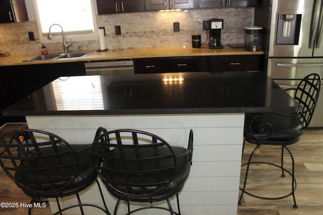 121 Pine Grove Rd, Newport, NC 28570 - kitchen with a sink, stainless steel appliances, a breakfast bar area, a kitchen island, and light wood-style flooring
