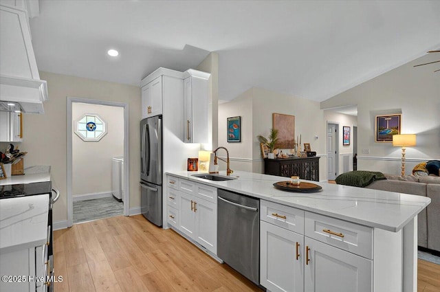 5892 Lycia Ln SW, Ocean Isle Beach, NC 28469 - kitchen featuring stainless steel appliances, a sink, a peninsula, open floor plan, and white cabinetry