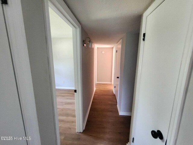 1007 Edmondson Ave, Tarboro, NC 27886 - corridor with wood finished floors, baseboards, and a textured ceiling