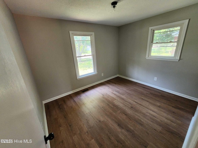1007 Edmondson Ave, Tarboro, NC 27886 - spare room featuring dark wood-style flooring, baseboards, and a textured ceiling