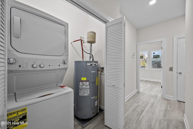 138 Sea Gull Ln, North Topsail Beach, NC 28460 - laundry room featuring stacked washer and clothes dryer, electric water heater, light wood finished floors, and baseboards