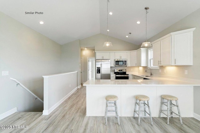 138 Sea Gull Ln, North Topsail Beach, NC 28460 - kitchen with appliances with stainless steel finishes, a sink, light wood-type flooring, lofted ceiling, and white cabinets