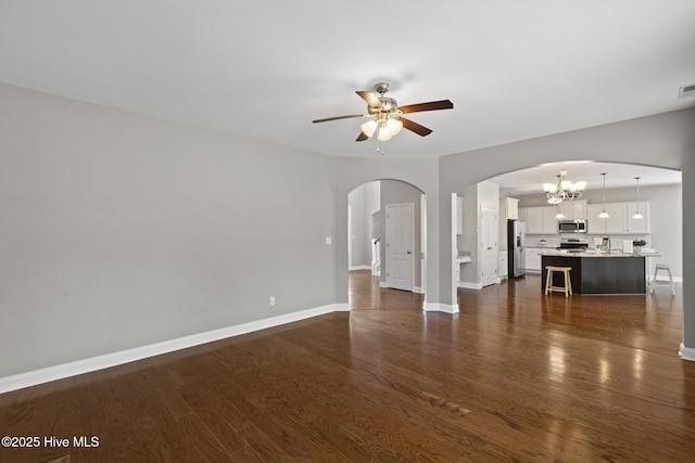 113 Percy Padgett Ct, Holly Ridge, NC 28445 - unfurnished living room with arched walkways, ceiling fan, a chandelier, and dark wood-type flooring