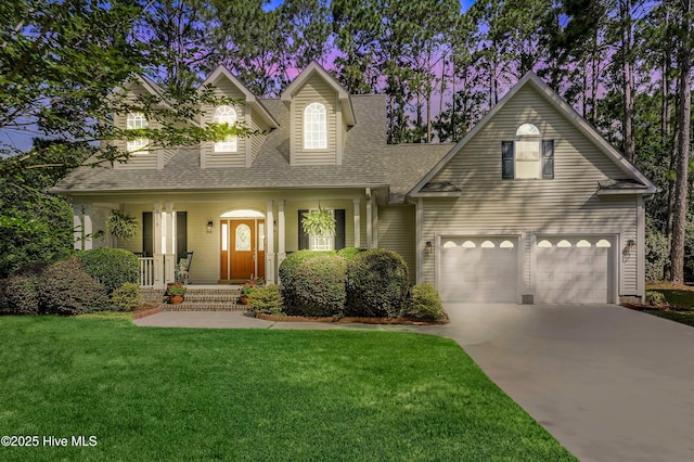 3878 White Blossom Cir, Southport, NC 28461 - cape cod home with roof with shingles, driveway, covered porch, a front yard, and a garage