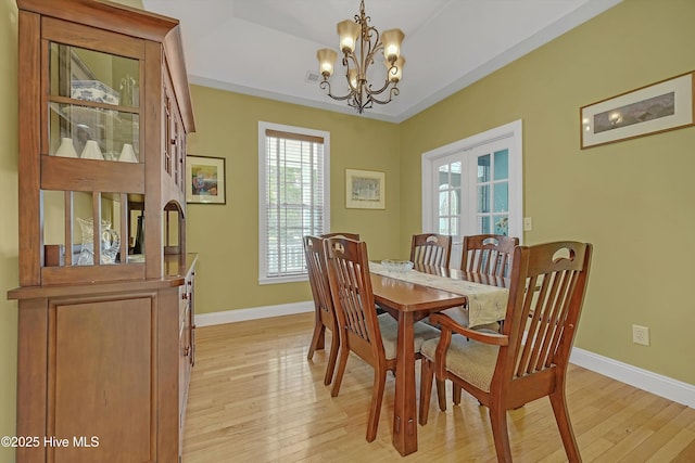 3878 White Blossom Cir, Southport, NC 28461 - dining room featuring light wood-type flooring, baseboards, a chandelier, and french doors