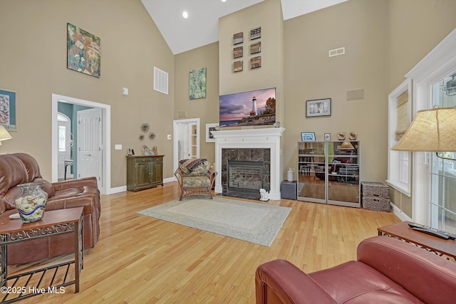 3878 White Blossom Cir, Southport, NC 28461 - living room with high vaulted ceiling, wood finished floors, a tiled fireplace, and baseboards
