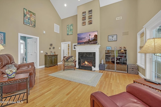 3878 White Blossom Cir, Southport, NC 28461 - living area with high vaulted ceiling, wood finished floors, a tile fireplace, and baseboards