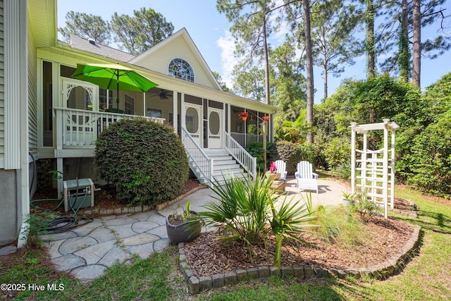 3878 White Blossom Cir, Southport, NC 28461 - view of side of home with a sunroom, a ceiling fan, and a patio