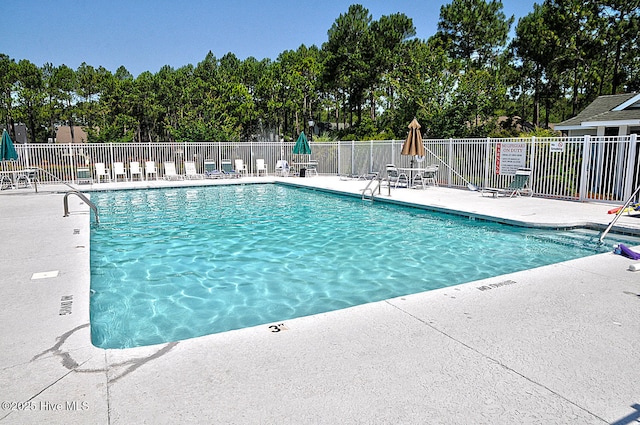 3878 White Blossom Cir, Southport, NC 28461 - community pool featuring a patio area and view of scattered trees