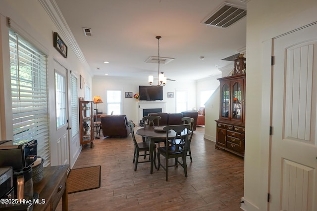 215 Chestwood Dr, Hubert, NC 28539 - dining room with crown molding, a fireplace, wood finished floors, baseboards, and recessed lighting