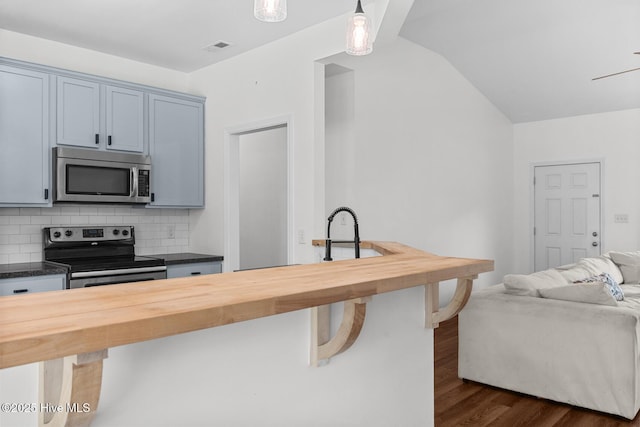 317 Inverness Dr, Hubert, NC 28539 - kitchen with stainless steel appliances, butcher block countertops, a breakfast bar, dark wood finished floors, and lofted ceiling