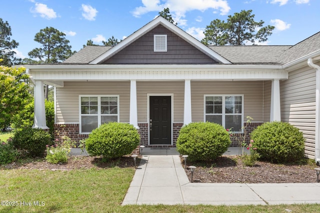 317 Inverness Dr, Hubert, NC 28539 - view of front facade featuring roof with shingles, covered porch, and brick siding