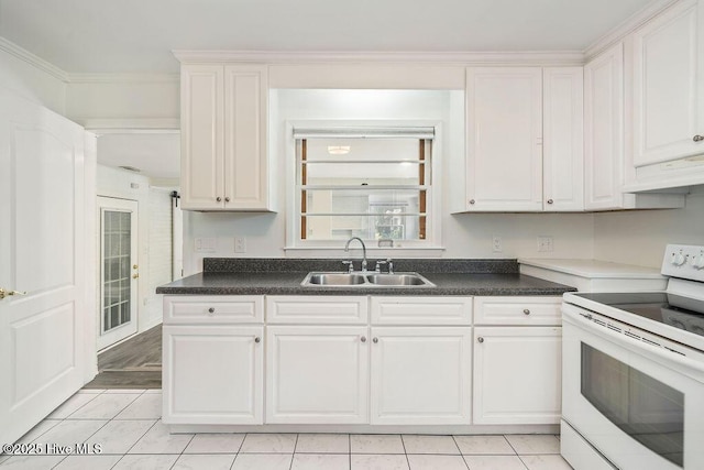 227 Rose Ave, Wilmington, NC 28403 - kitchen with white electric range oven, under cabinet range hood, white cabinets, light tile patterned floors, and dark countertops