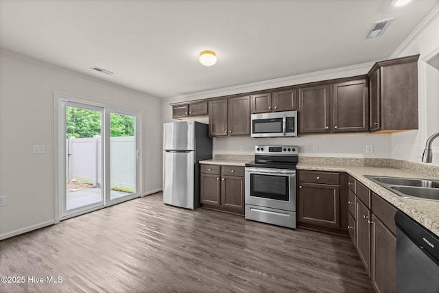 312 Glenellen Loop Rd, Midway Park, NC 28544 - kitchen with stainless steel appliances, a sink, dark brown cabinetry, crown molding, and light countertops