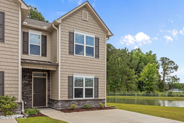 312 Glenellen Loop Rd, Midway Park, NC 28544 - view of front of house featuring stone siding, a water view, a shingled roof, and a patio