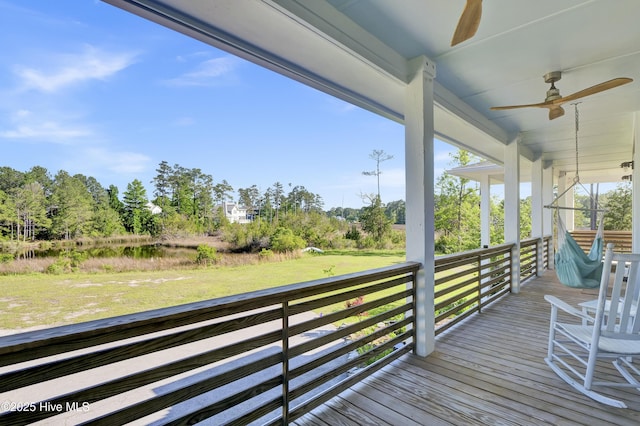 1246 Heron Run Dr, Wilmington, NC 28403 - wooden porch featuring a ceiling fan, a lawn, and view of scattered trees