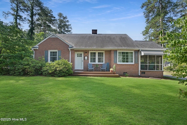 1206 Lancaster Ln, Rockingham, NC 28379 - view of front of home featuring brick siding, a front yard, and a chimney