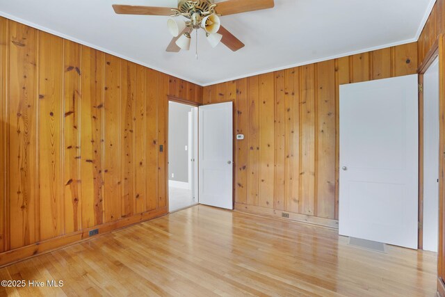 1206 Lancaster Ln, Rockingham, NC 28379 - unfurnished bedroom with ornamental molding, wood finished floors, wooden walls, and ceiling fan