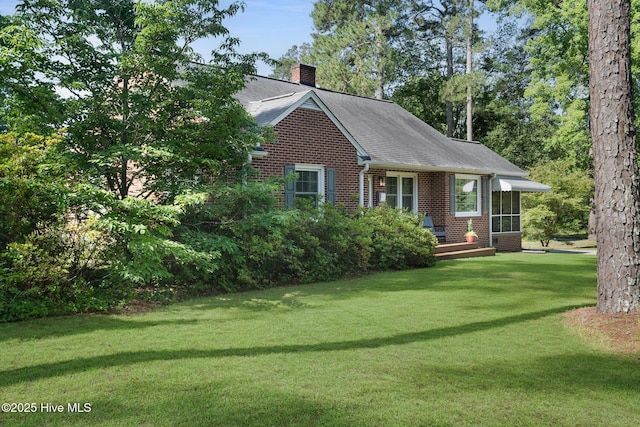 1206 Lancaster Ln, Rockingham, NC 28379 - view of front of home featuring brick siding, a chimney, a front yard, and roof with shingles