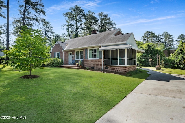 1206 Lancaster Ln, Rockingham, NC 28379 - view of front of house with a sunroom, a front lawn, brick siding, and a shingled roof