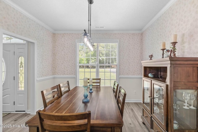 154 Dockside Dr, Jacksonville, NC 28546 - dining space featuring light wood-type flooring, plenty of natural light, a wainscoted wall, crown molding, and wallpapered walls