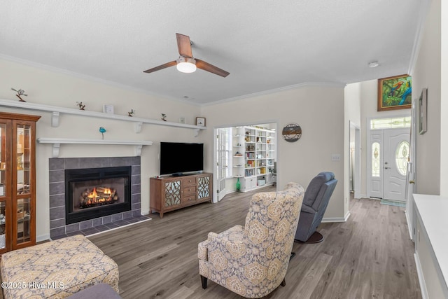 154 Dockside Dr, Jacksonville, NC 28546 - living room with a ceiling fan, wood finished floors, a tiled fireplace, ornamental molding, and a textured ceiling