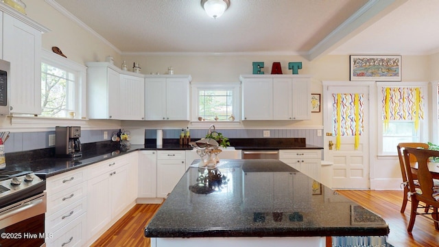 305 E New Hampshire Ave, Southern Pines, NC 28387 - kitchen with stainless steel appliances, healthy amount of natural light, white cabinetry, and crown molding