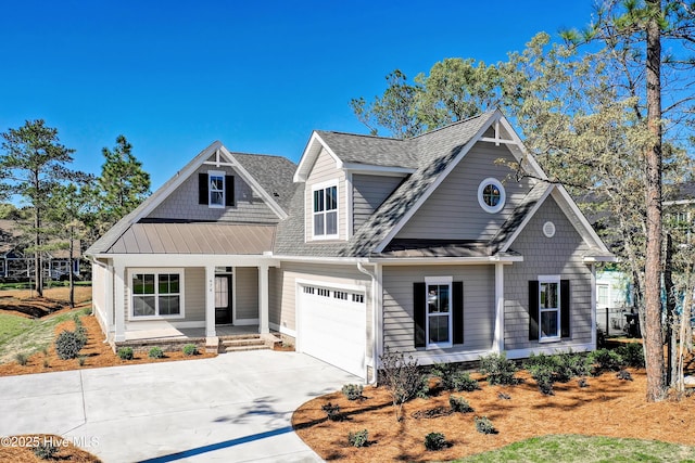 947 Ashburton Rd SE, Bolivia, NC 28422 - view of front of property with a porch, concrete driveway, a shingled roof, an attached garage, and a standing seam roof