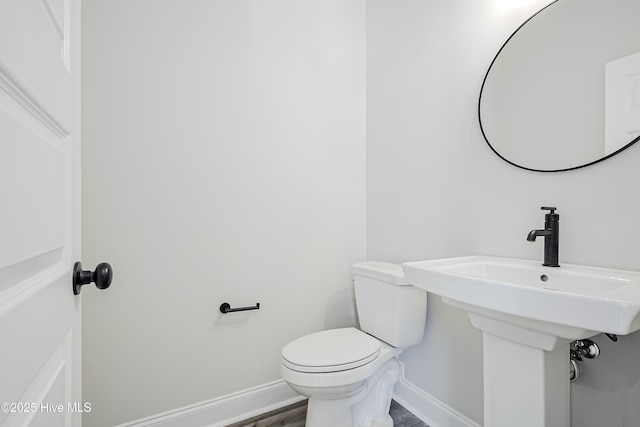 947 Ashburton Rd SE, Bolivia, NC 28422 - bathroom with baseboards, toilet, wood finished floors, and a sink