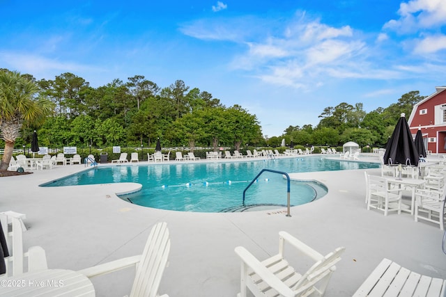 94 Field Planters Cir, Calabash, NC 28467 - community pool featuring a patio area and view of wooded area