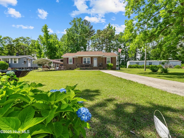 323 Alexander Rouse Rd, Kinston, NC 28504 - view of front facade featuring a carport, a front lawn, and brick siding