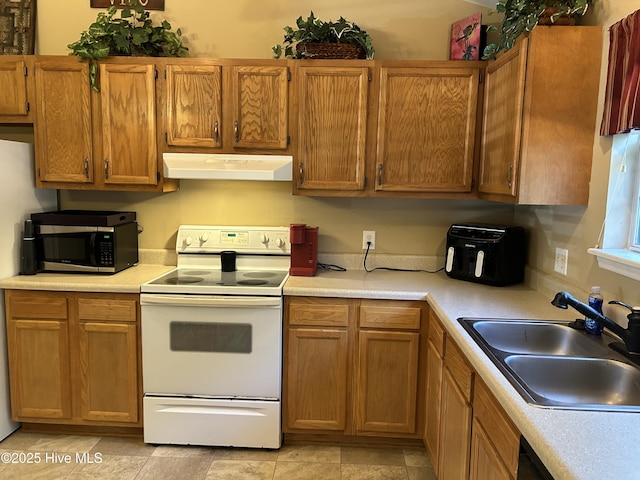 1404 Angels End Unit B, Greenville, NC 27858 - kitchen featuring white electric range oven, under cabinet range hood, stainless steel microwave, a sink, and light countertops